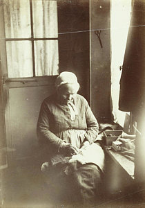 old-woman-sitting-by-a-window-sewing-anonymous-artokoloro